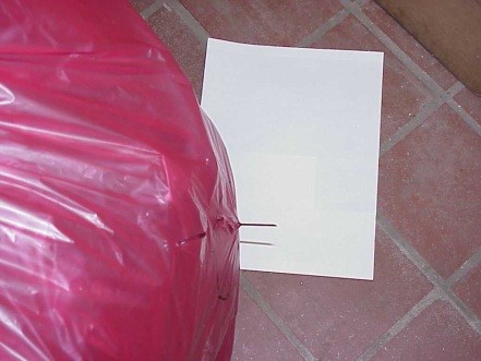 Needle breaking through a red biohazardous bag — incorrect disposal causing injury to custodial staff
